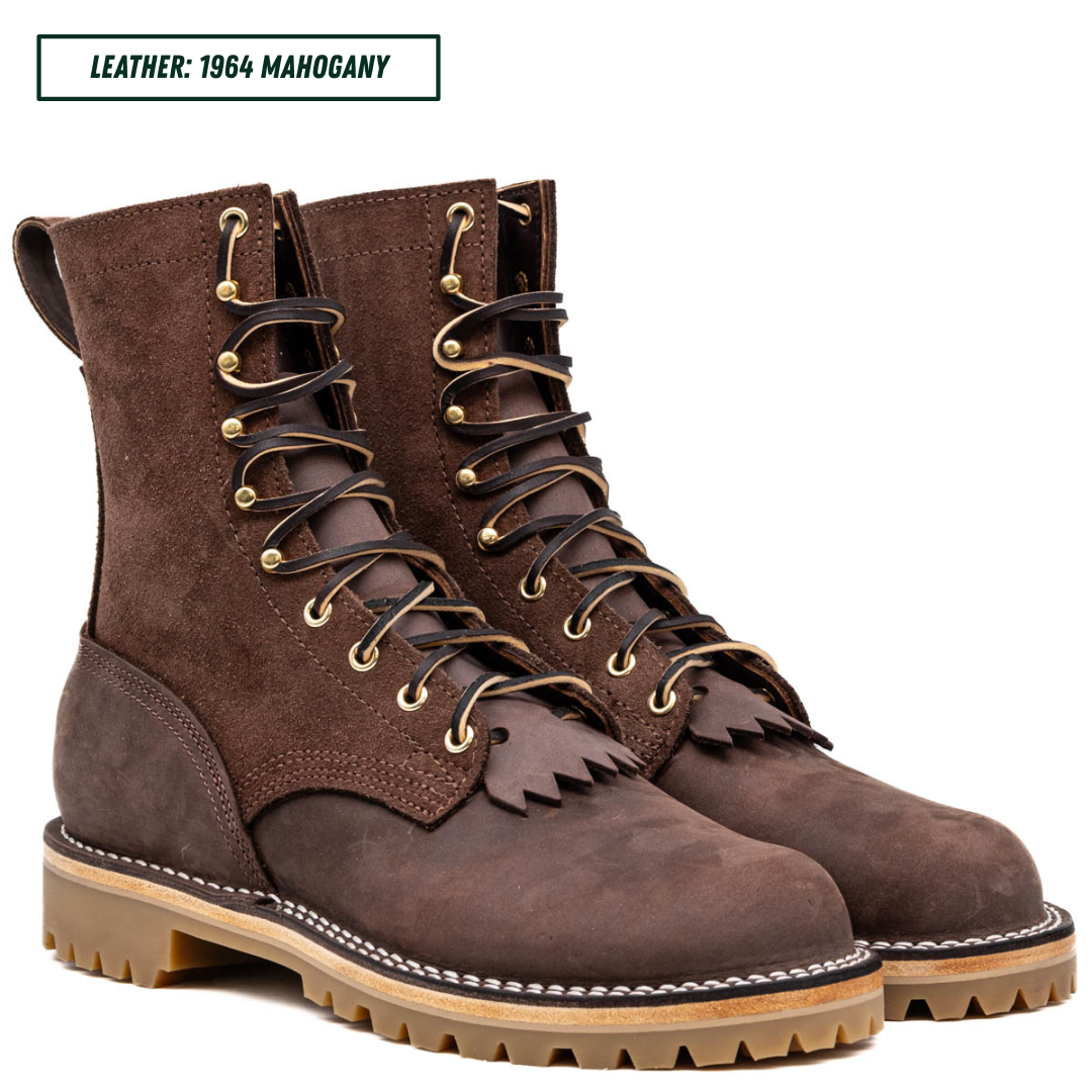 A pair of dark brown suede and leather lace-up boots with fringe detailing, shown on a white background with a text label reading 'LEATHER: 1964 MAHOGANY'.