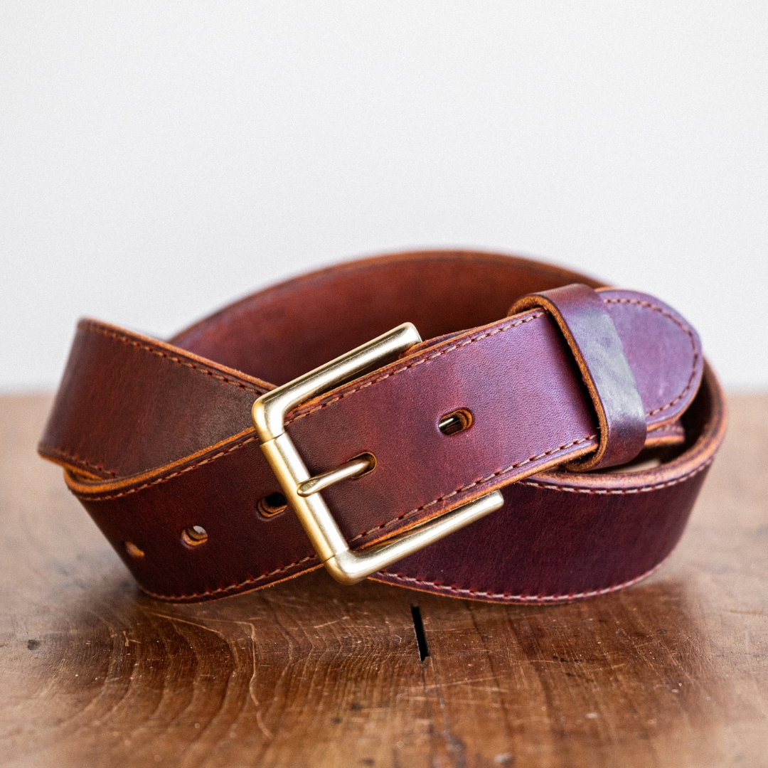 Cypress Raisin Cherry Heritage belt sitting on wooden crate in front of white backdrop