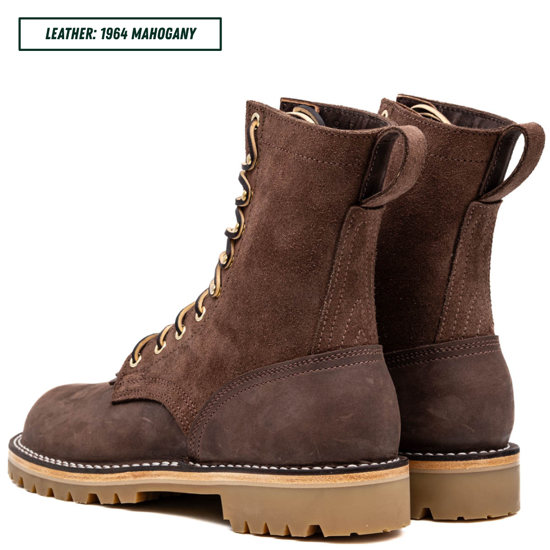 A pair of dark brown suede lace-up boots with tan soles and gold-tone laces, shown from the side and back on a white background. A text label in the top left reads 'LEATHER: 1964 MAHOGANY'.