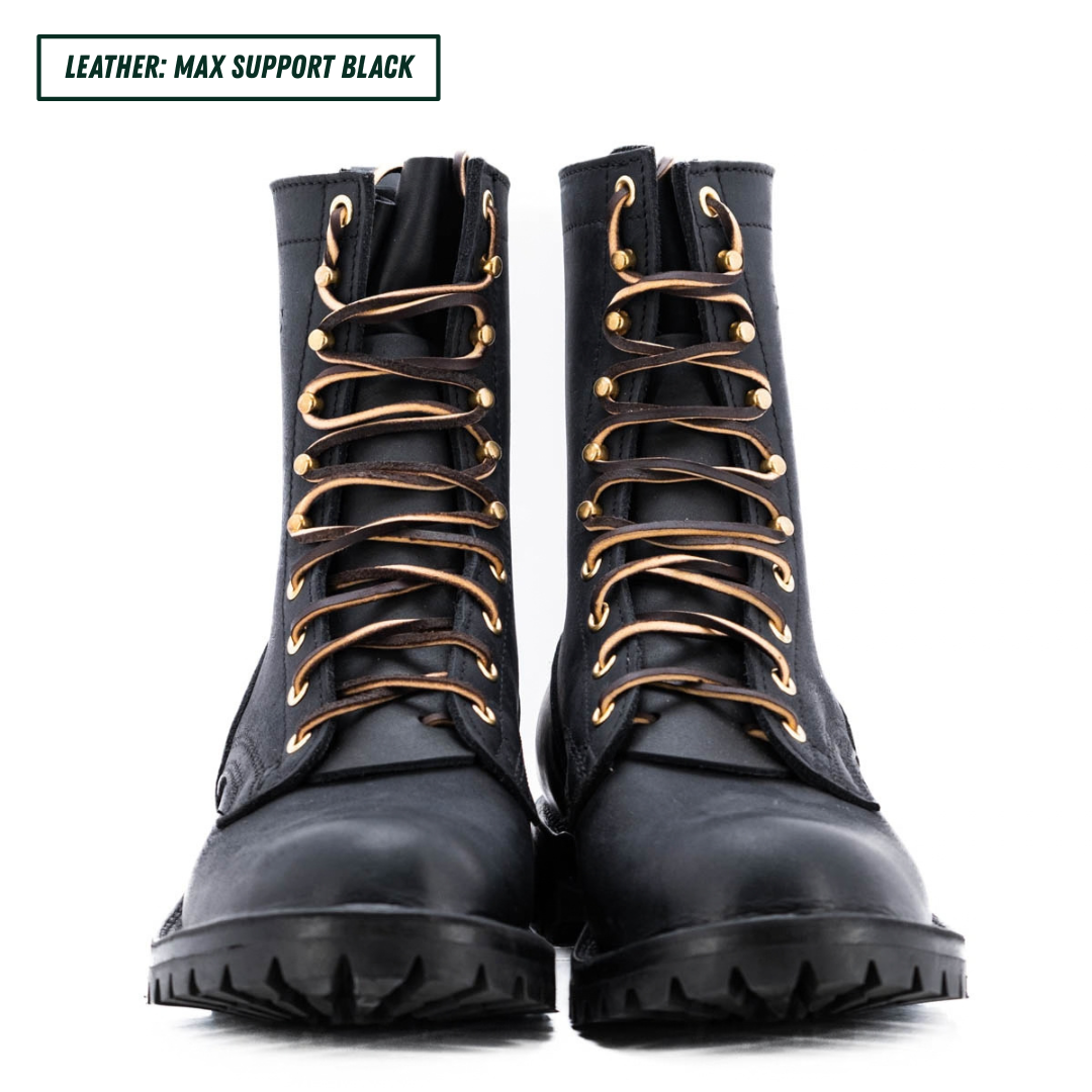 A pair of black leather lace-up combat boots with gold-tone eyelets and a rugged sole, shown on a white background with a text label in the top left corner.