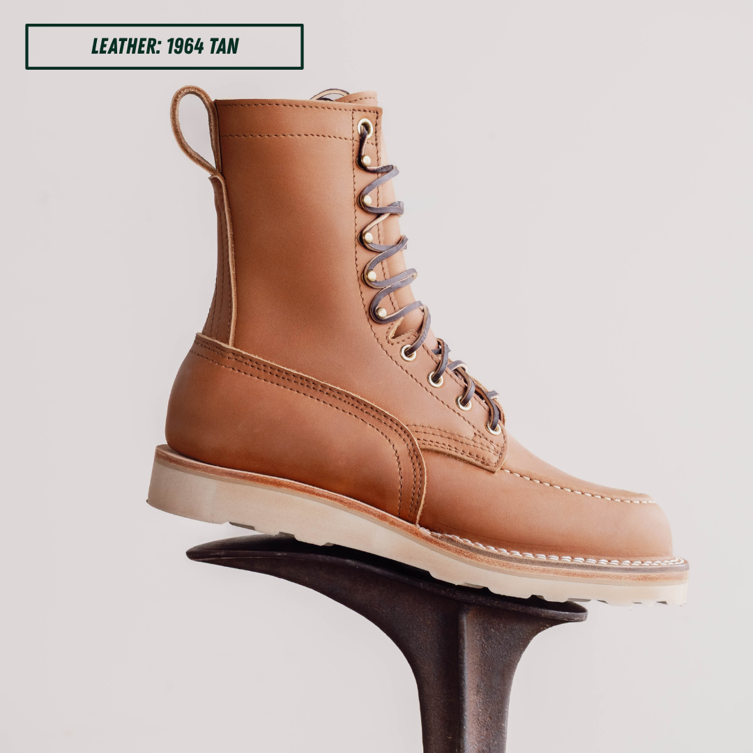 HD moc toe work boot sitting on boot jack. Label on top left of picture that reads "LEATHER: 1964 TAN."