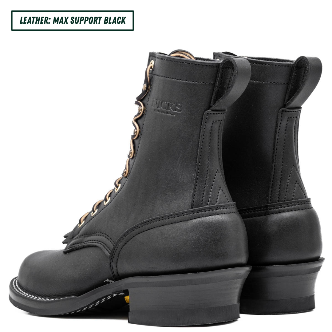 A pair of black leather lace-up boots shown from the side and back on a white background, with a text label in the top-left corner reading 'LEATHER: MAX SUPPORT BLACK'. The brand name 'DICKS' is embossed on the side of the boot.