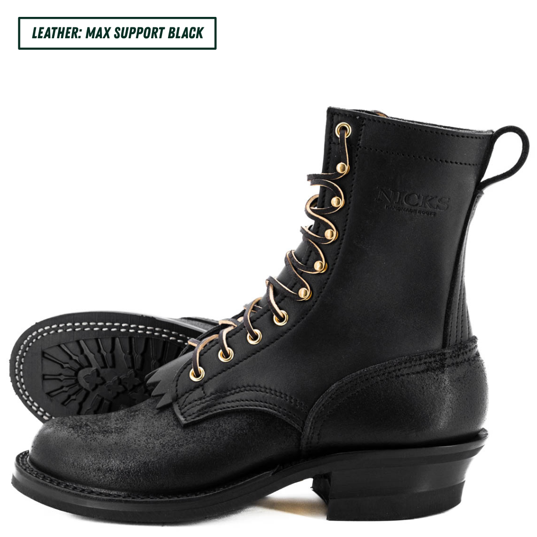 A pair of black leather lace-up boots with gold-tone eyelets and a low stacked heel, shown on a white background. One boot is in profile, and the other is turned to show the outsole.