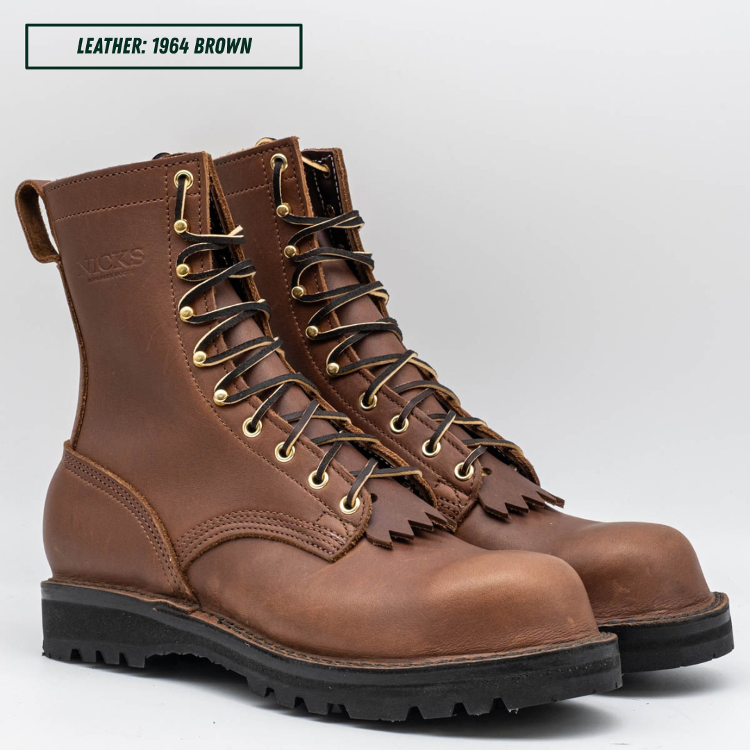 A pair of brown leather lace-up work boots with gold-toned metal eyelets and black soles, shown on a light gray background with a text label reading 'LEATHER: 1964 BROWN'.