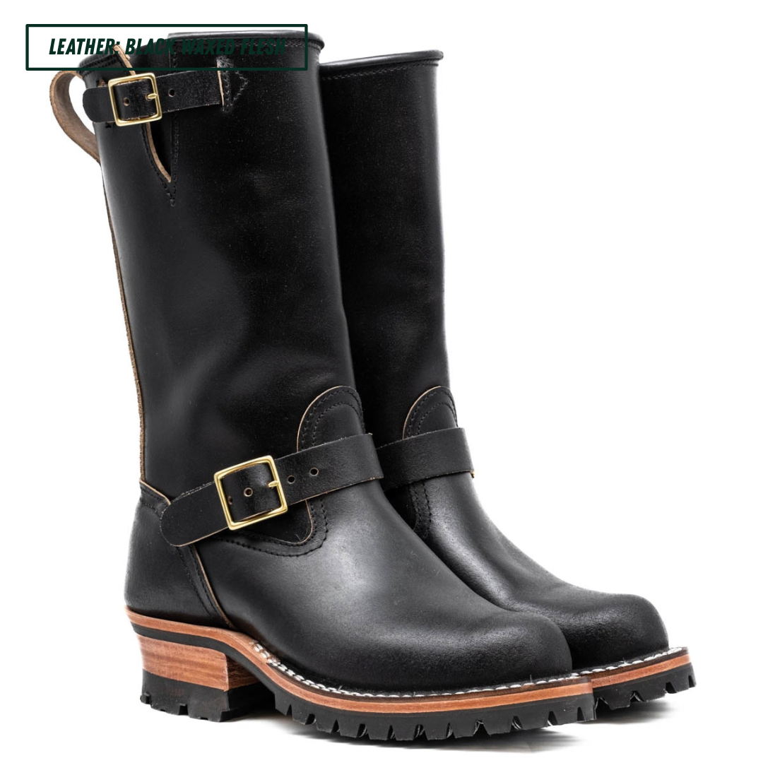 Pair of black leather boots with buckles on a white background