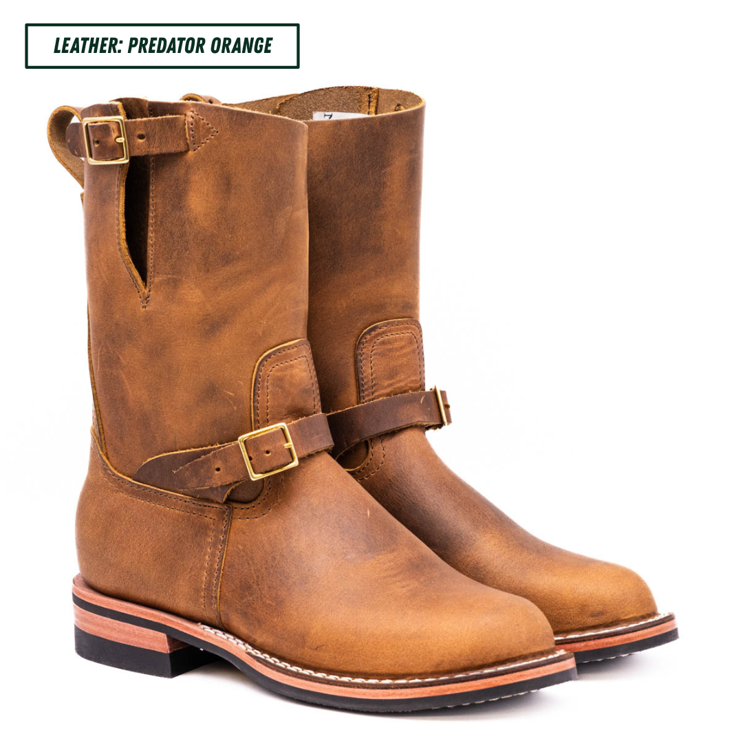 A pair of distressed brown leather boots with buckle straps, shown on a white background with a text label at the top reading 'LEATHER: PREDATOR ORANGE'.