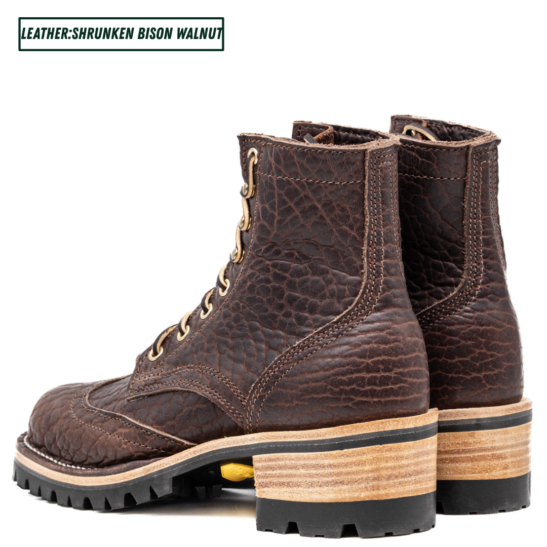 A pair of dark brown leather lace-up boots with a textured, shrunken finish and stacked wooden heels, shown against a plain white background with a text label in the top left corner.