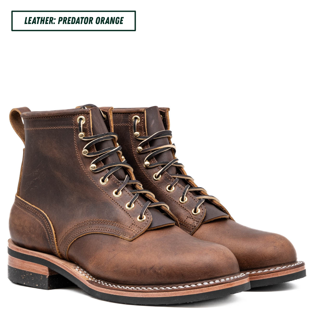 A pair of dark brown leather lace-up boots with distressed detailing, shown on a white background with a text label in the top left corner that reads 'LEATHER: PREDATOR ORANGE'.