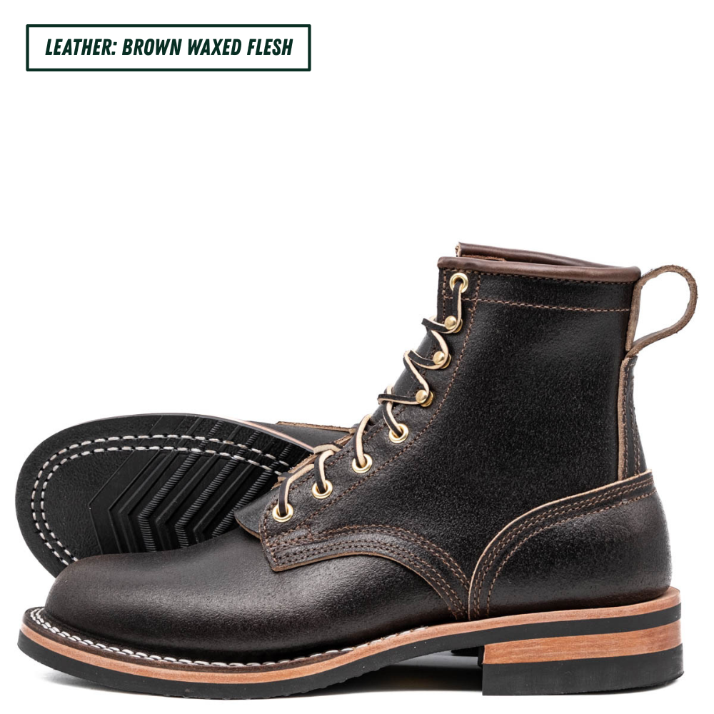 A pair of dark brown waxed leather lace-up boots shown on a white background, with a text label in the top-left corner reading 'LEATHER: BROWN WAXED FLESH'. The boots feature gold-tone eyelets, contrast stitching, and a stacked sole with a tan mid-layer.