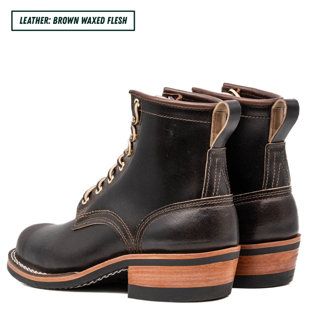 A pair of dark brown leather lace-up ankle boots with stacked wood-look heels, shown from a side-rear angle on a white background. A text label in the top-left corner reads 'LEATHER: BROWN WAXED FLESH'.