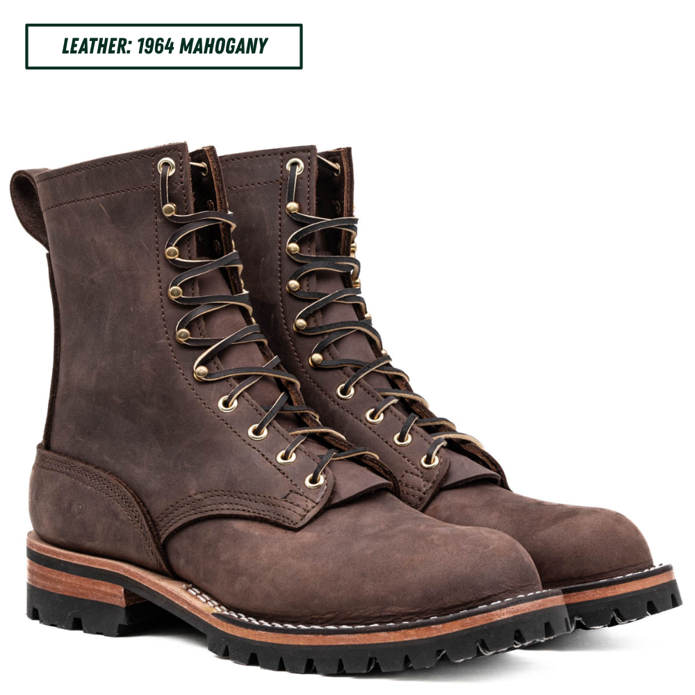 A pair of dark brown leather lace-up boots with brass eyelets and black laces, shown on a white background with a text label in the top left corner that reads 'LEATHER: 1964 MAHOGANY'.
