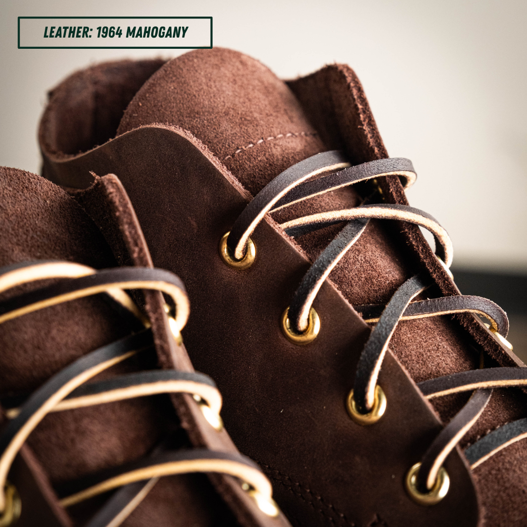 Close-up of a brown leather lace-up shoe with dark brown laces, brass eyelets, and light tan contrast stitching. A text label in the top left reads 'LEATHER: 1964 MAHOGANY'.