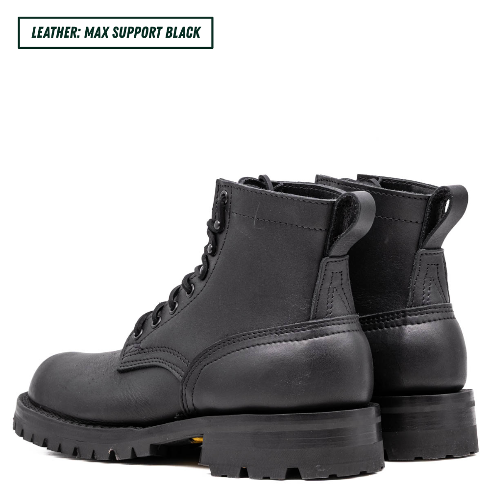 A pair of black leather lace-up ankle boots with thick lug soles, shown from a three-quarters angle on a white background. A text label in the top-left corner reads 'LEATHER: MAX SUPPORT BLACK'.