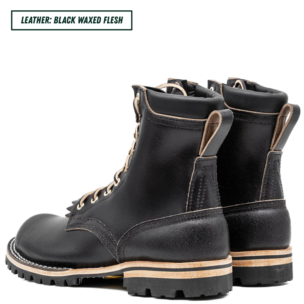 A pair of black waxed leather lace-up boots shown from the side and back on a white background, with a text label in the top-left corner reading 'LEATHER: BLACK WAXED FLESH'.
