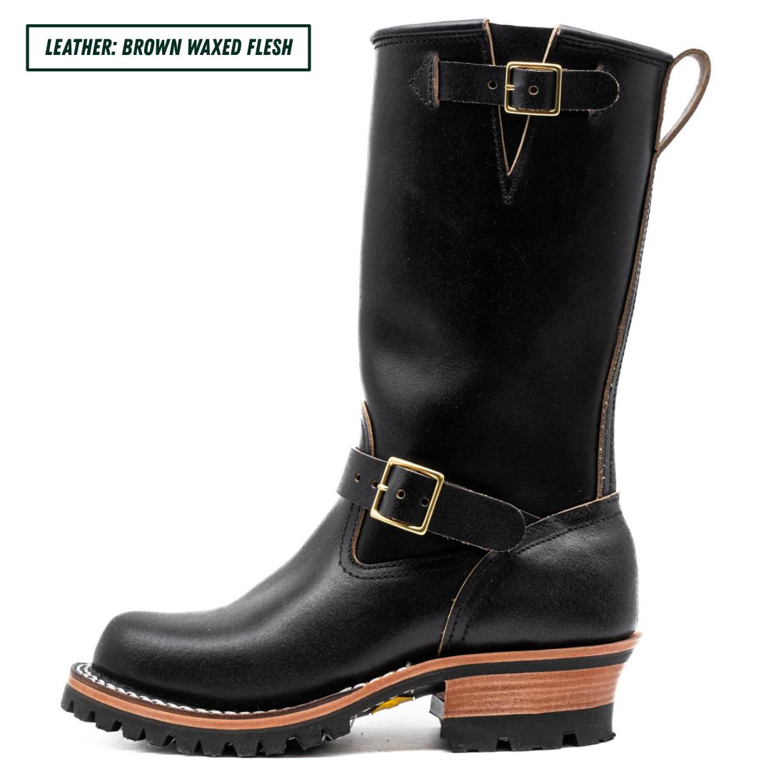 Black leather boot with gold buckles on a white background