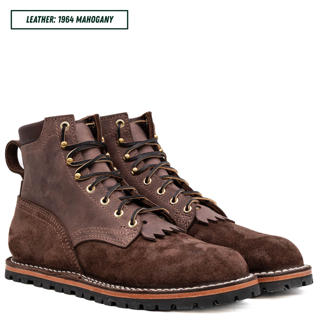 A pair of dark brown suede lace-up boots with gold-tone eyelets and black laces, shown on a white background with a text label reading 'LEATHER: 1964 MAHOGANY' in the top left corner.