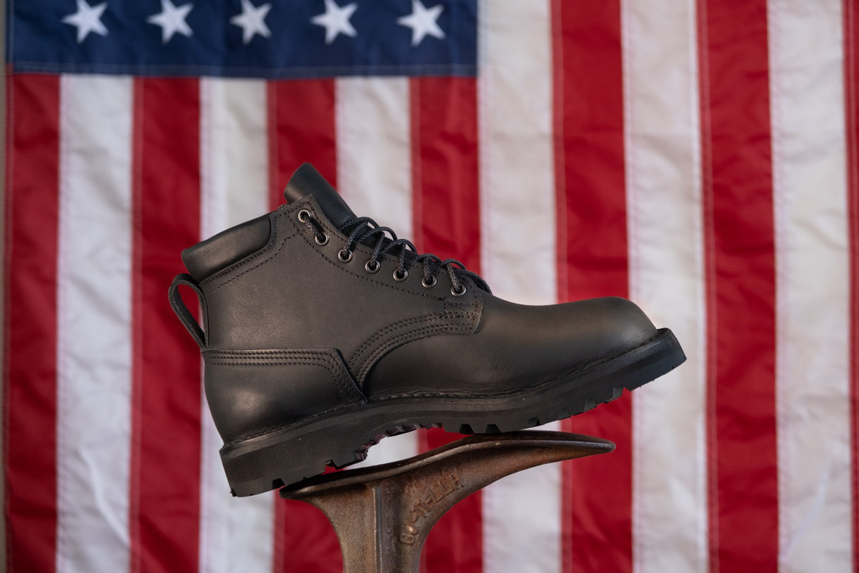 5 inch black boot with padded color. Vibram Sierra aggressive sole. Pull loop on back. American flag in the background.