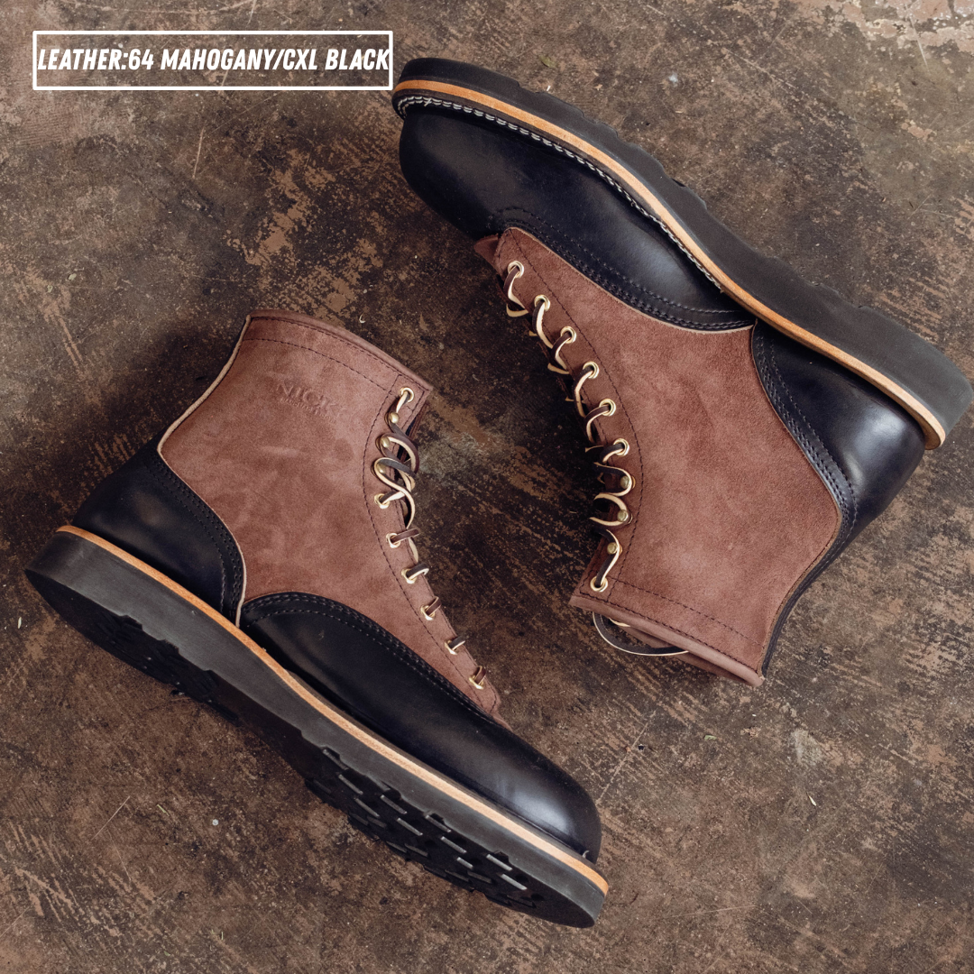 Two tone boots with dark brown roughout uppers and glossy black lowers laying on textured concrete. Top left reads 'LEATHER:64 MAHOGANY/CXL BLACK'
