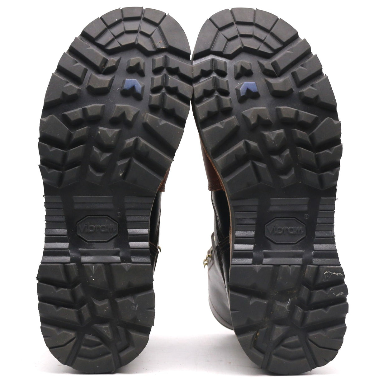 A pair of black lug sole boots shown from the back, displaying deep tread patterns and the embossed brand name 'Vionik' on the soles against a white background.