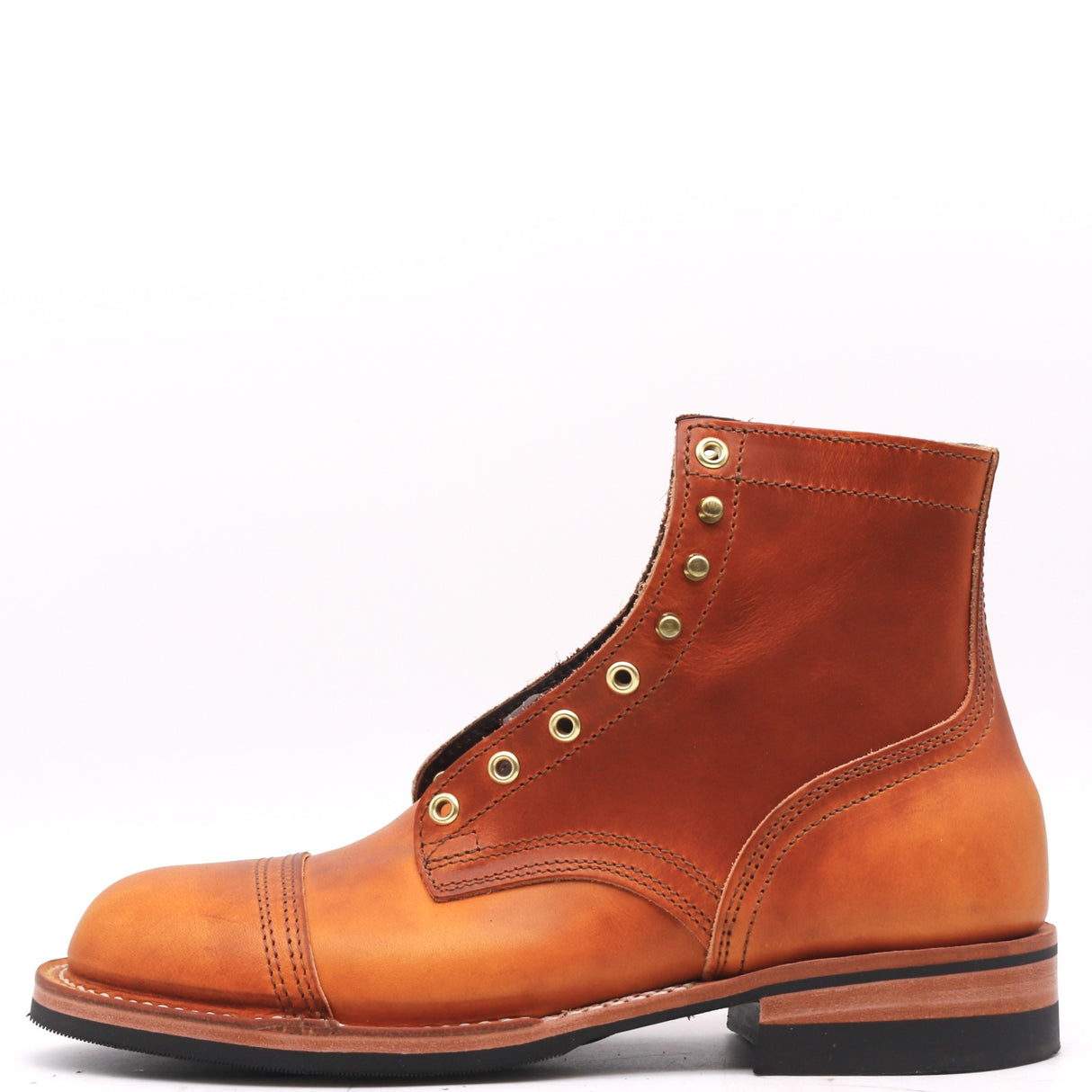 A single leather ankle boot in a warm cognac brown, featuring brass grommets, a cap toe, and a black sole, photographed against a plain white background.