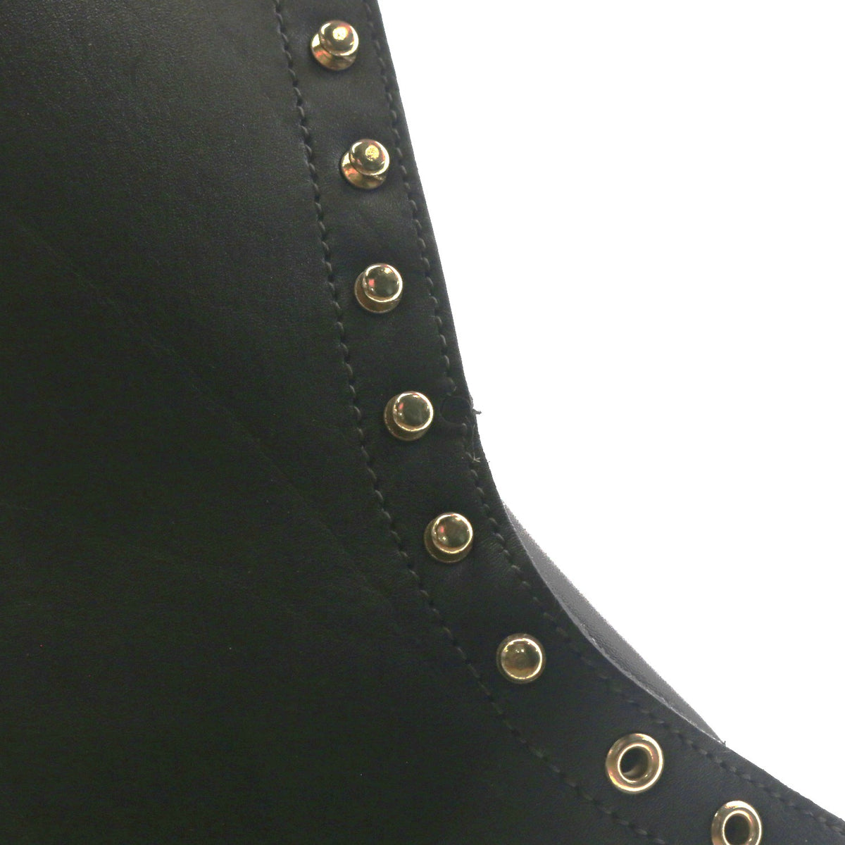 Close up of the uppers of a black boot showing the hardware. A circular indent can be seen in the leather.