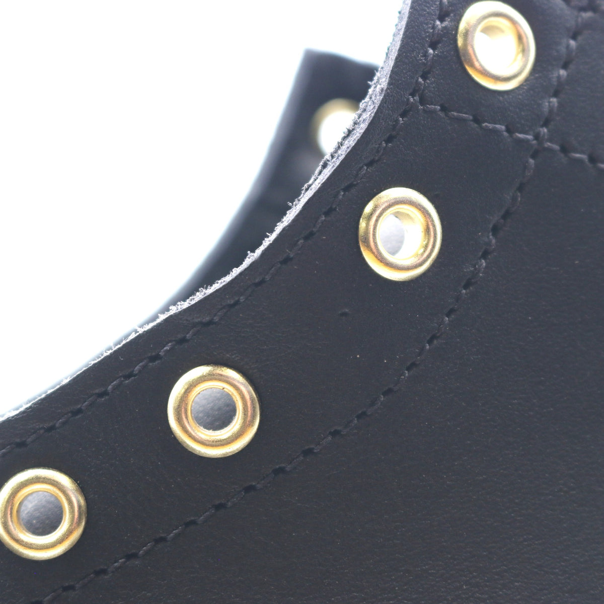 Close up of the hardware of a black leather boot. The hardware is visibly mis-spaced.