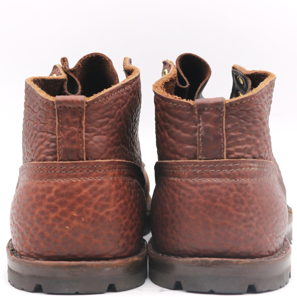 A pair of brown pebbled leather lace-up boots shown from the back against a plain white background.