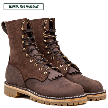 A pair of dark brown suede and leather lace-up boots with fringe detailing, shown on a white background with a text label reading 'LEATHER: 1964 MAHOGANY'.