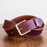 Cypress Raisin Cherry Heritage belt sitting on wooden crate in front of white backdrop