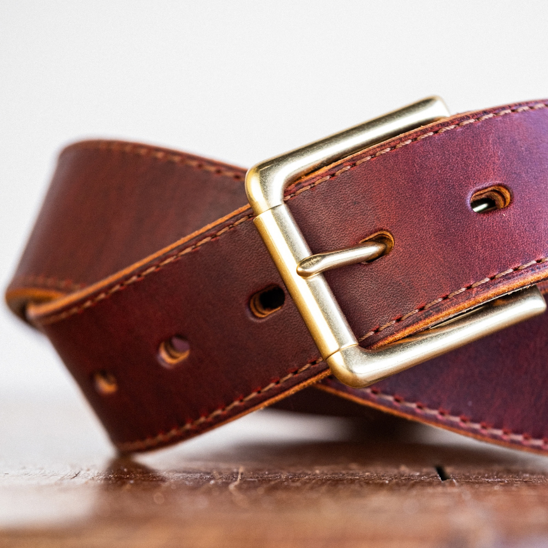 Cypress Raisin Cherry Heritage belt sitting on wooden crate in front of white backdrop