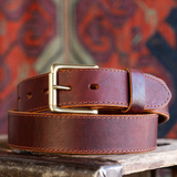 Cypress Raisin Cherry Heritage belt sitting on wooden crate in front of red backdrop