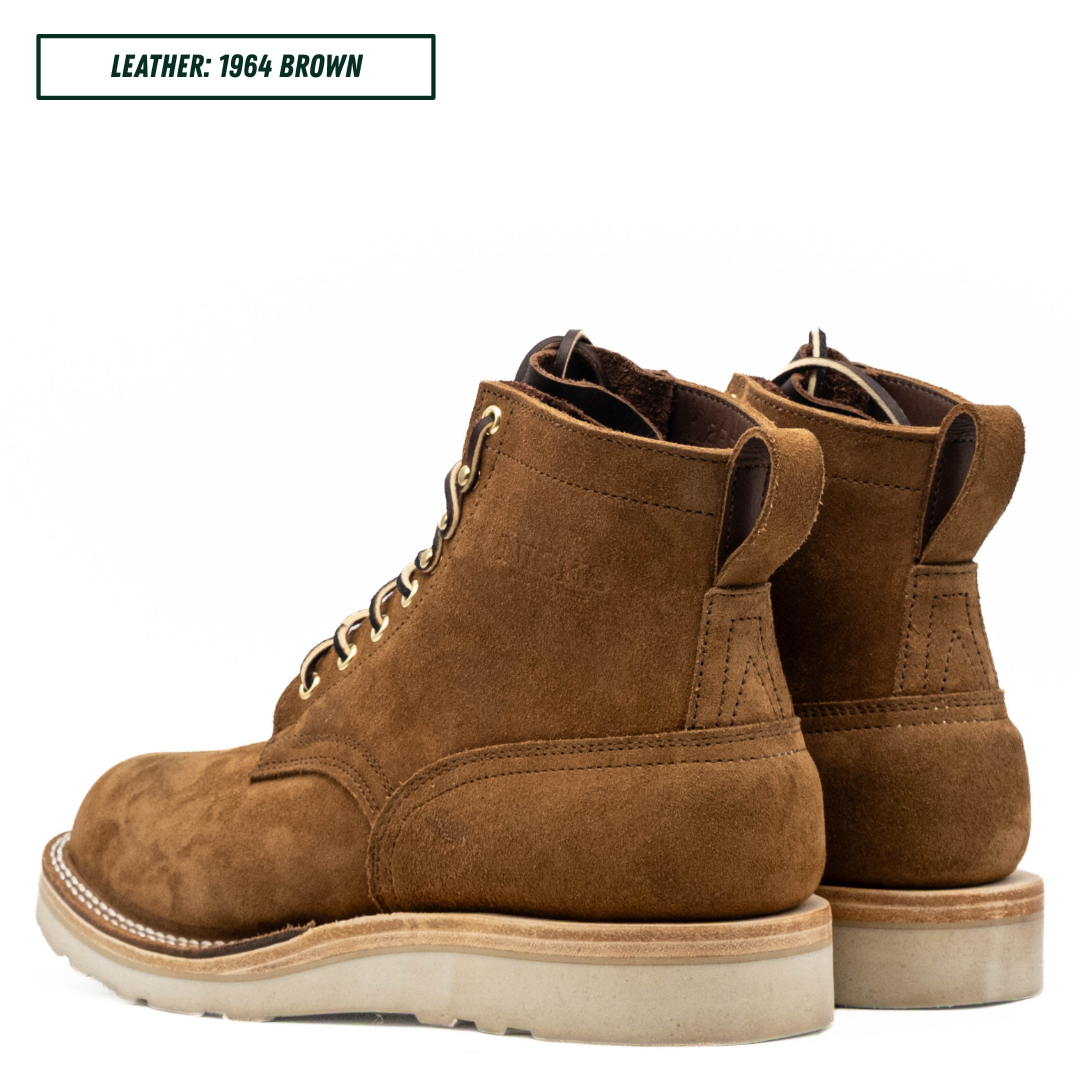 A pair of brown suede lace-up ankle boots shown from the side on a white background, with a text label in the top-left corner reading 'LEATHER: 1964 BROWN'.