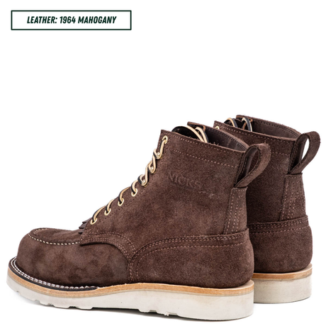 A pair of dark brown suede work boots with beige laces and off-white soles, shown on a white background with a text label in the top left corner reading 'LEATHER: 1964 MAHOGANY'.