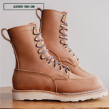 HD moc toe work boots, sitting on wooden table with one propped up. Label on top left of picture that reads "LEATHER: 1964 TAN."