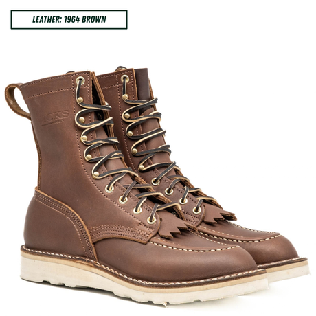A pair of brown leather lace-up boots with gold-toned metal eyelets and a thick off-white sole, shown on a white background with a text label reading 'LEATHER: 1964 BROWN'.