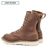 A pair of brown leather lace-up boots shown on a white background, with a text label in the top-left corner reading 'LEATHER: 1964 BROWN'. The boots feature a rich medium brown leather upper, brass eyelets, off-white stitching, and a thick off-white sole.