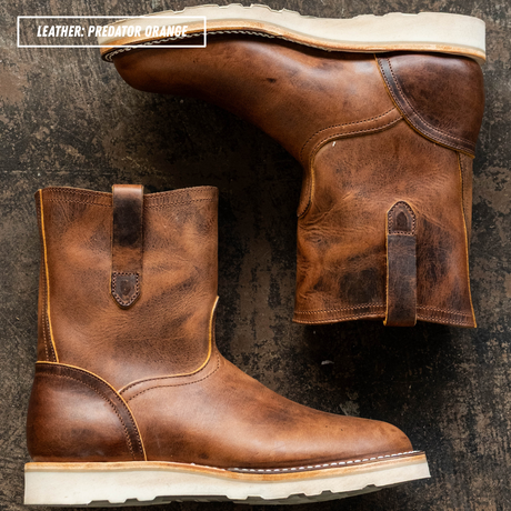 Two brown leather mid-calf boots with distressed finishes and off-white soles, arranged on a dark textured surface. A text overlay in the top left reads 'LEATHER: PREDATOR ORANGE'.