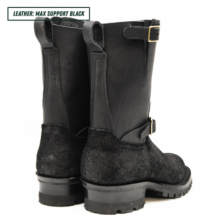 Pair of black riding boots with a buckle on a white background