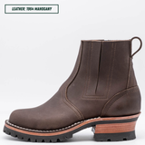 A dark brown leather Chelsea-style ankle boot with a chunky stacked heel, black lug sole, and a light tan midsole section. Top left reads "LEATHER: 1964 MAHOGANY."