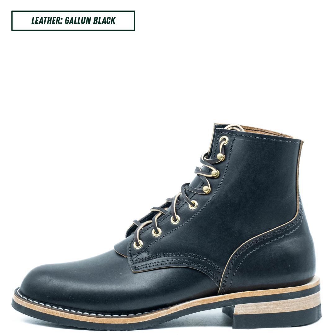 A single dark navy leather lace-up ankle boot shown in profile on a white background, with a text label in the top-left corner reading 'LEATHER: GALLUN BLACK'. The boot has brass eyelets, a light tan midsole, and a black sole.