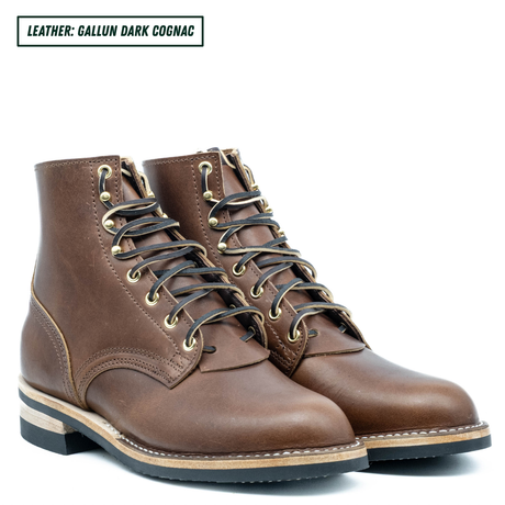 A pair of dark cognac brown leather lace-up ankle boots with brass eyelets and black laces, shown on a white background with a text label in the top left corner.