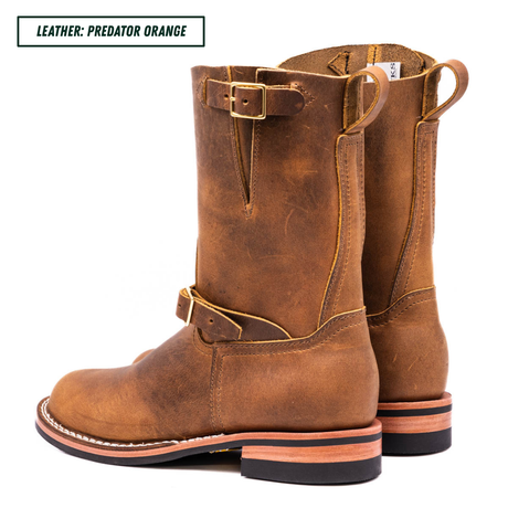 A pair of mid-calf western boots in distressed brown leather, shown from a side profile view against a white background. A text label in the top left corner reads 'LEATHER: PREDATOR ORANGE'.