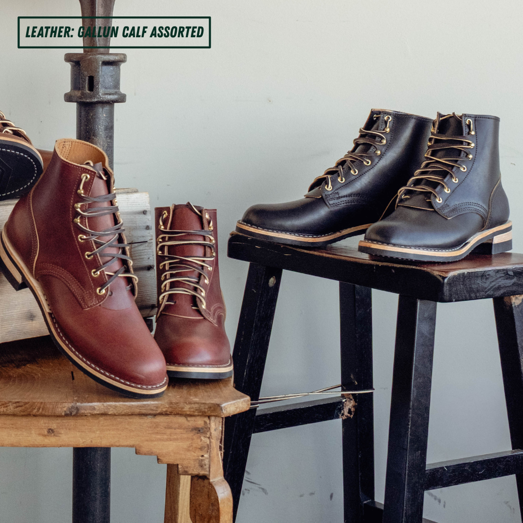 Two pairs of ankle boots in assorted brown and black shades displayed on rustic wooden stools and a metal stand against a light gray wall. A text label in the top left reads 'LEATHER: GALLUN CALF ASSORTED'.
