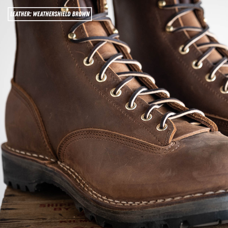 Weathershield brown lace to toe leather boots with padded collar. Detail shot of lace to toe patterning. Label on top left stating "Leather: Weathershield Brown."