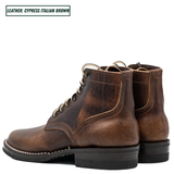 A pair of distressed brown leather lace-up ankle boots shown from a three-quarter angle on a white background, with a text label in the top-left corner reading 'LEATHER: CYPRESS ITALIAN BROWN'.