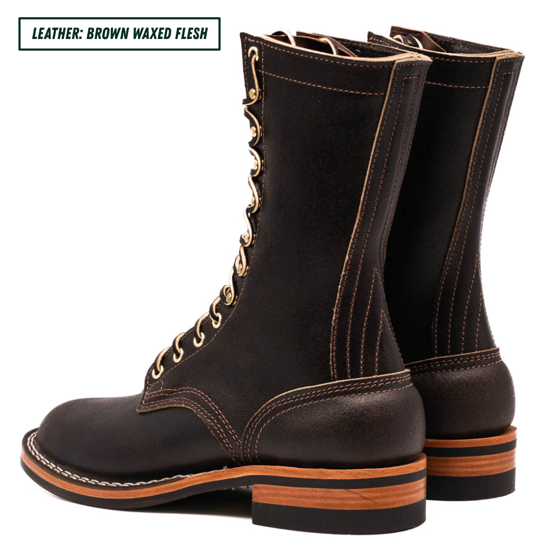 A pair of dark brown waxed leather lace-up boots shown from a side profile view on a white background, with a text label in the top-left corner reading 'LEATHER: BROWN WAXED FLESH'.