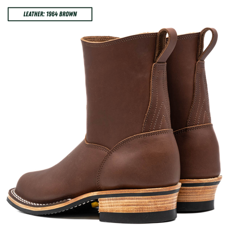 A pair of brown leather mid-calf boots with stacked wood-look heels, shown from a side angle on a white background. A text label in the top-left corner reads 'LEATHER: 1964 BROWN'.