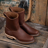 A pair of brown leather mid-calf boots with white contrast stitching and stacked heels, displayed on a rustic wooden crate with a wooden background. A text overlay in the top left reads 'LEATHER: 1964 BROWN'.