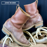 A pair of brown leather ankle boots displayed on a burlap surface with antlers, against a dark blue background. A text overlay in the top left reads 'LEATHER: 1964 BROWN'.