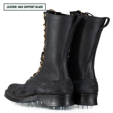 A pair of black leather knee-high boots with metal spikes on the soles, shown from a three-quarters angle on a white background. A text overlay in the top-left corner reads 'LEATHER: MAX SUPPORT BLACK'.